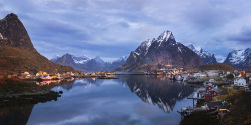 Scenic view of lake by mountains against sky during winter