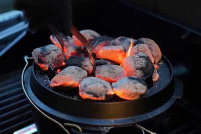 High angle view of glowing embers on barbecue grill with dutch oven 