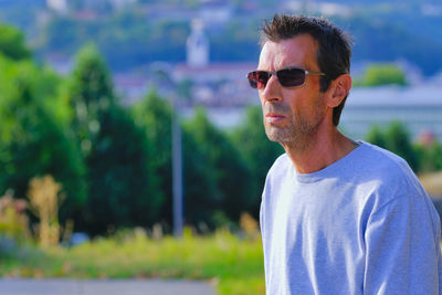 Portrait of young man wearing sunglasses standing outdoors