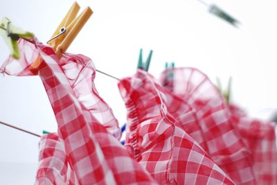 Close-up of clothes hanging on rope against sky