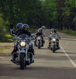 People riding motorcycle on road