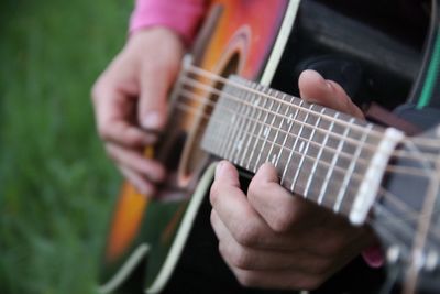 Close-up mid section of a man playing guitar