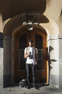 Full length portrait of man standing against wall