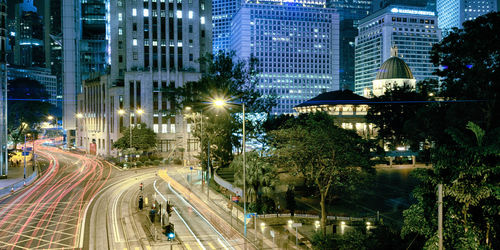 Light trails on city street by buildings at night