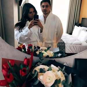 Young couple holding bouquet at home