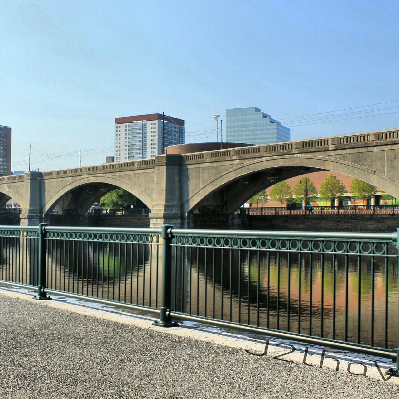 architecture, built structure, connection, bridge - man made structure, clear sky, engineering, bridge, building exterior, transportation, city, railing, suspension bridge, arch, sky, river, tree, outdoors, road, day, arch bridge