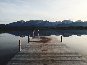 Jetty over lake against sky