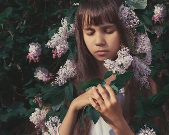 Beautiful woman with pink flower in sunlight