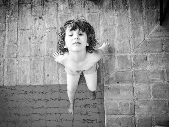 High angle view of shirtless boy sitting at poolside