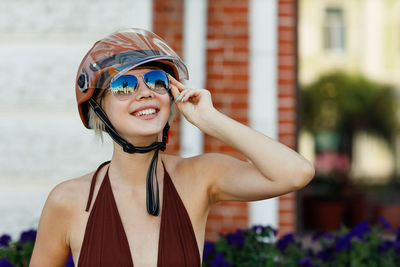 Portrait of young woman wearing sunglasses while standing outdoors