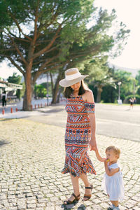 Full length of woman with umbrella on street