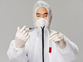 Young scientist holding sample against white background