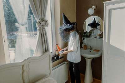Young woman sitting on bed at home