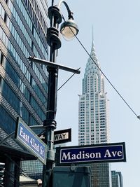 Low angle view of road sign against buildings