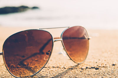 Close-up of sunglasses on sand