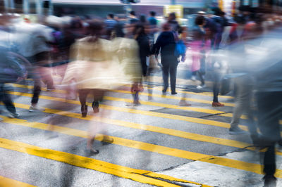 Blurred motion of people walking on zebra crossing