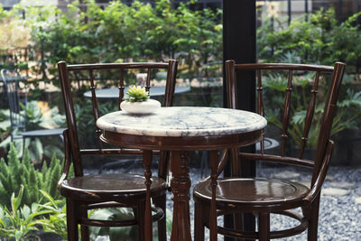 Empty chairs and table in yard