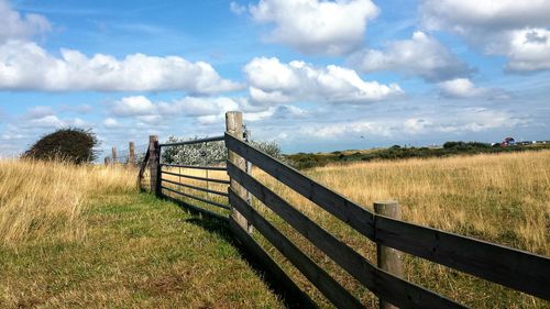 Scenic view of grassy field against cloudy sky