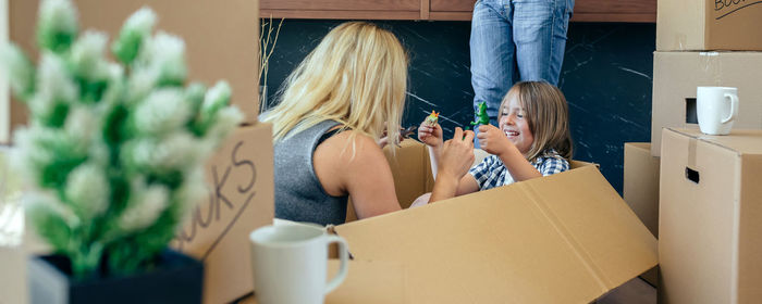 Parents with son unpacking boxes at home