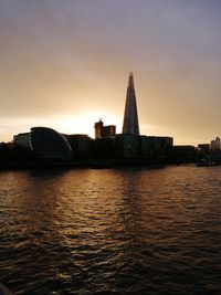 View of buildings at waterfront during sunset