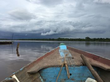 Fishing boats moored in lake against sky