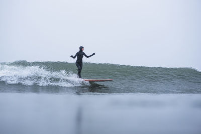 Woman surfing during winter snow