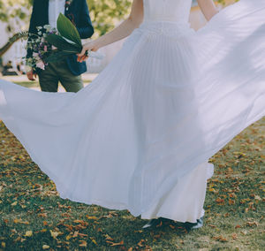 Low section of woman standing on field