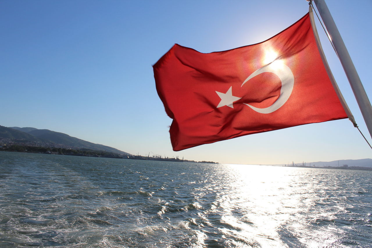 RED FLAG ON SEA AGAINST CLEAR SKY