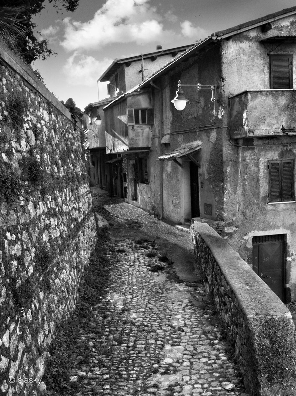 architecture, built structure, building exterior, the way forward, house, residential structure, sky, residential building, building, old, diminishing perspective, steps, wall - building feature, narrow, low angle view, day, window, brick wall, stone wall, no people