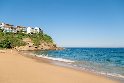 Scenic view of beach against clear blue sky