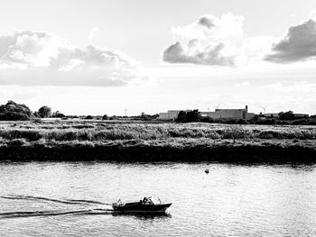 Boat sailing on river against sky