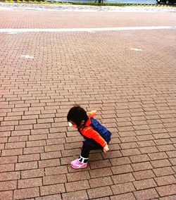 High angle view of boy playing on footpath