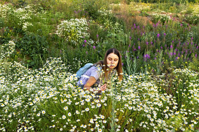 Portrait of woman with purple flowers on field