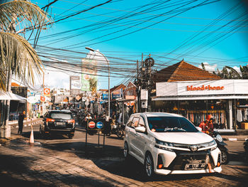 Cars on street by buildings against sky