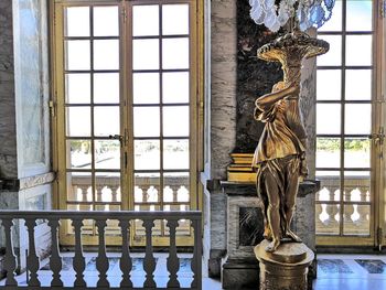 Statue against window of building