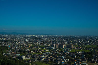 High angle view of cityscape against blue sky