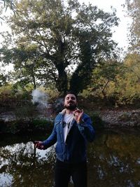 Portrait of young man standing in forest