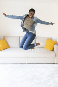 Smiling young woman on sofa at home