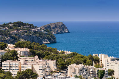 High angle view of townscape by sea against clear sky