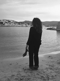 Rear view of woman standing on beach