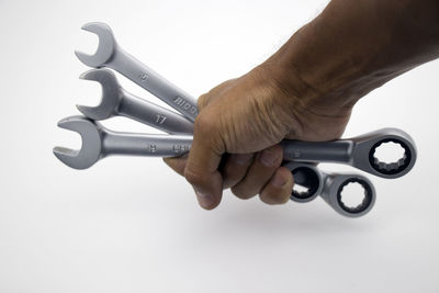 Close-up of hand holding toy against white background