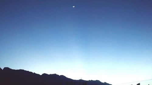 Low angle view of mountains against clear blue sky