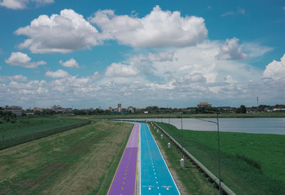 Road amidst field against sky