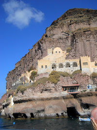 Buildings by sea against sky