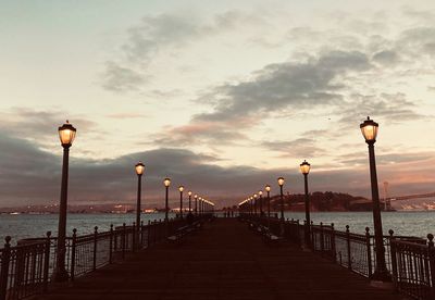 Street lights on bridge against sky