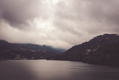 Scenic view of sea and mountains against sky