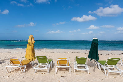 Chairs on beach against sky