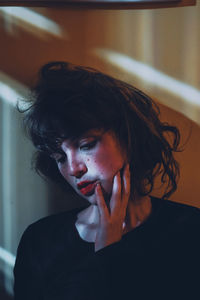 Close-up of woman against wall at home