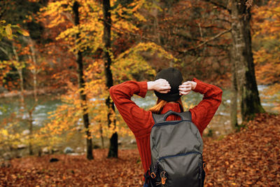 Person standing by tree in forest during autumn