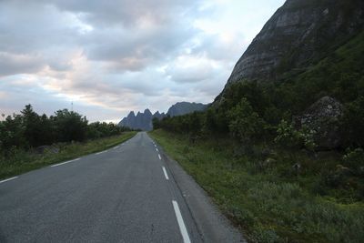 Road amidst trees against sky